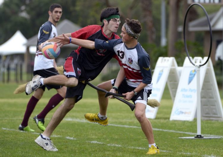 In this April 12, 2013, file photo, Silicon Valley Skrewts' Logan Anbinder, center, drives to the goal between the University of Ottawa's Matthew Bunn, right, and Ahmed Al-Slaq during a scrimmage at the Quidditch World Cup in Kissimmee, Fla. Just like the Harry Potter books, Quidditch requires each member of a seven-person team, three chasers, two beaters, a keeper and a seeker, to keep a broom between his or her legs at all times. 