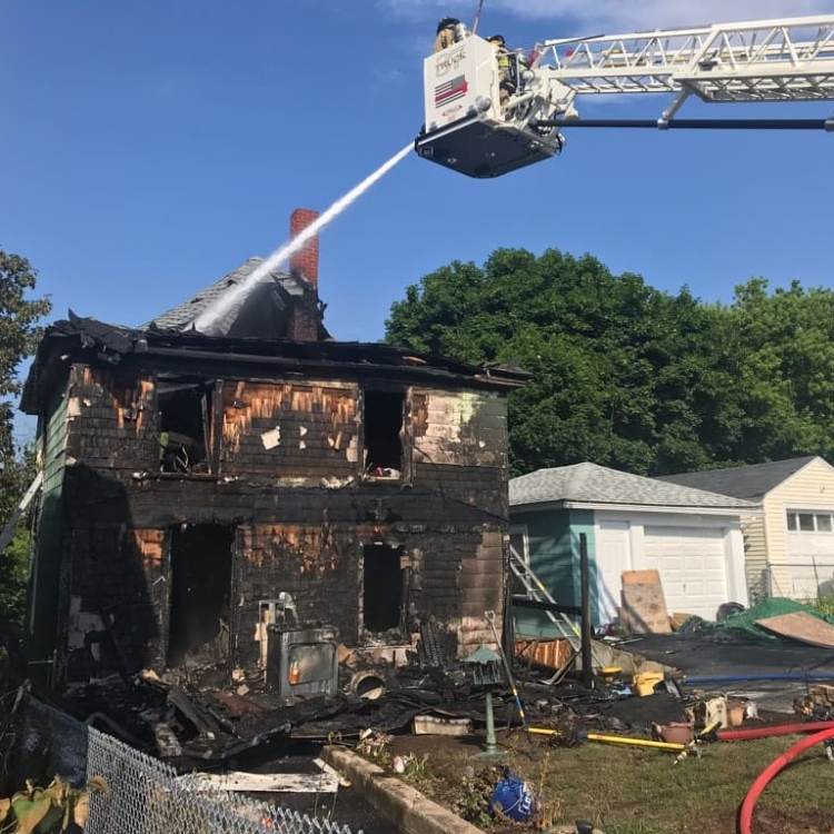 A Sanford ladder truck hoses down hot spots on Saturday at 26 Montreal St. The single-family home was destroyed by the arson fire.
