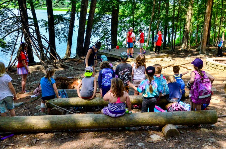 Campers assemble to watch a comedy quiz show Wednesday during a Kennebec Valley YMCA day camp at Camp KV in Readfield. 