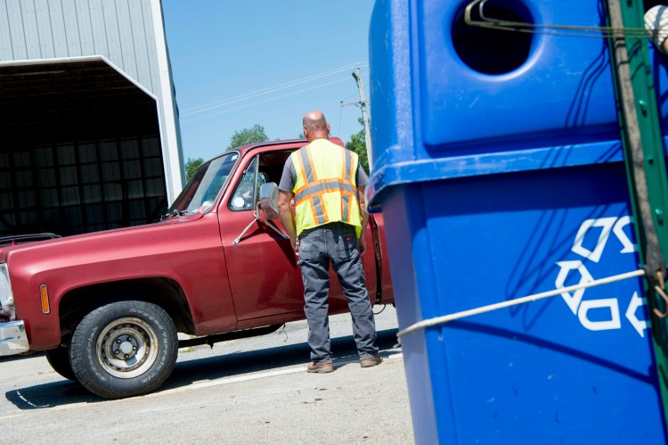 A worker at the Clinton-Benton Solid Waste and Recycling Transfer who did not want to be identified helps a resident with his refuse on Wednesday. 