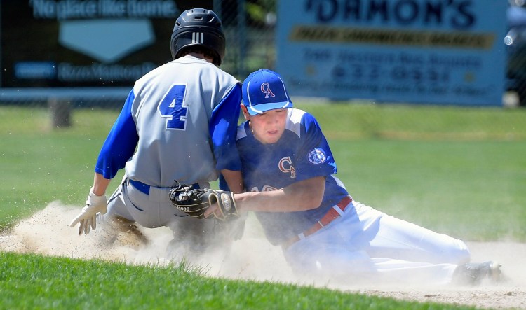 Capital Area's Noah Reed applies a tag to Saco's Andrew Charron on Monday in Augusta.