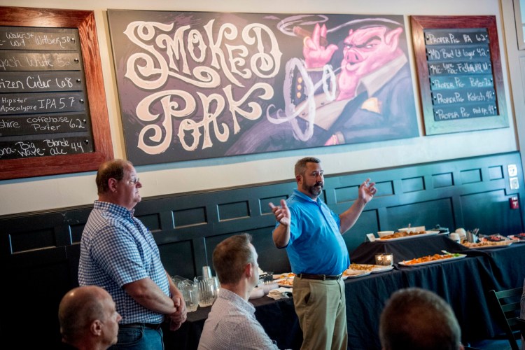 Derek Albert, senior project manager for Landry/French Construction, speaks with local business owners Tuesday about the upcoming construction of the new Colby hotel during an informational meeting at the Proper Pig in downtown Waterville.