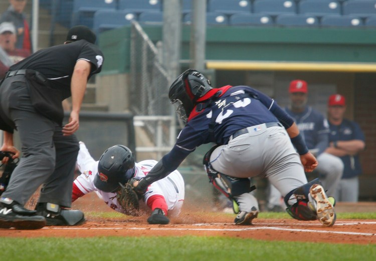Luke Tendler of Sea Dogs is tagged out at home by Ali Sanchez of Binghamton while trying to score on a two-out hit by Joey Curletta in the first inning of the first game Thursday night. Binghamton won 3-2.