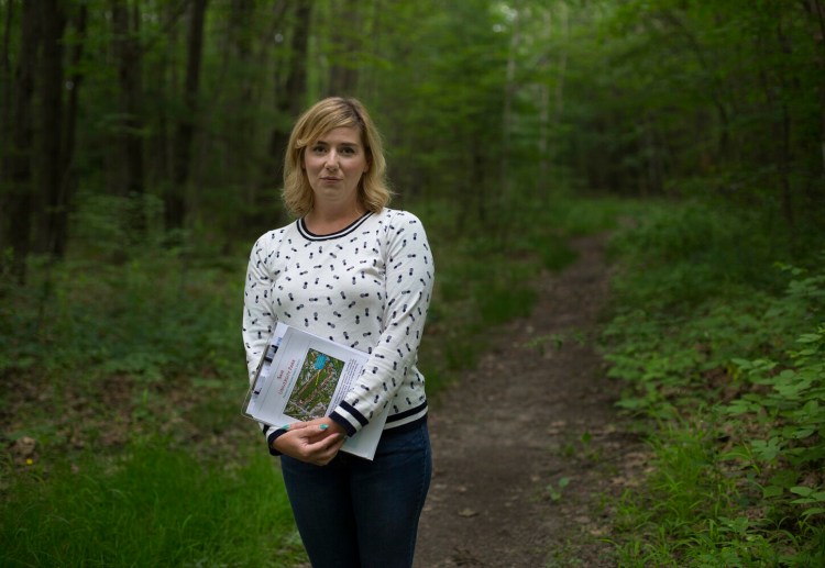 Elizabeth Rose is organizing opposition to a developer's proposal to rezone forestland near Morrill's Corner to allow construction of 20 duplexes. She is pictured Wednesday on Harvard Path, which would become a paved street behind her house.