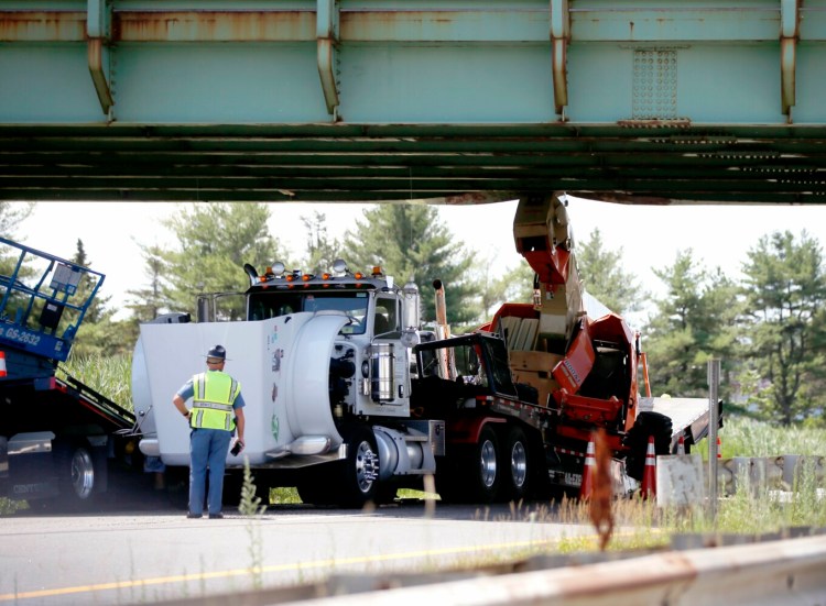A truck hauling a small crane struck an overpass on the Maine Turnpike in the northbound lane near Exit 45 in South Portland on Monday. 