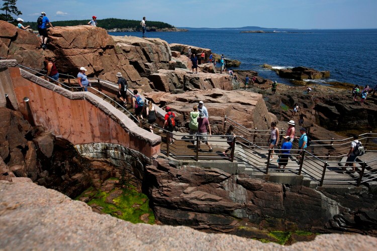 Park visitors fill the stairs and surrounding rock outcroppings at Thunder Hole, one of the most popular spots in Acadia National Park. 