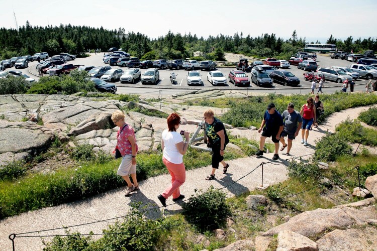 Visitors walk a path from the 145-space parking lot to the Cadillac Mountain summit earlier this month. On July 5, the park had its busiest day ever – 35,000 visitors. Park resources bent under the weight of the 755 radio calls made to rangers, and the 20 calls to 911 for injuries or rescues.