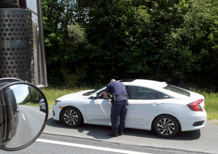 A Maine State Police trooper confers with a driver after pulling the vehicle over Monday on Interstate 95 in West Gardiner because of distracted driving. The department's Commercial Vehicle Unit was scrutinizing the operation of drivers across Maine for distracted driving last week as part of a nationwide effort. Troopers traveling in a tractor-trailer truck between Topsham and West Gardiner directed colleagues to drivers using cellphones or not wearing seat belts.