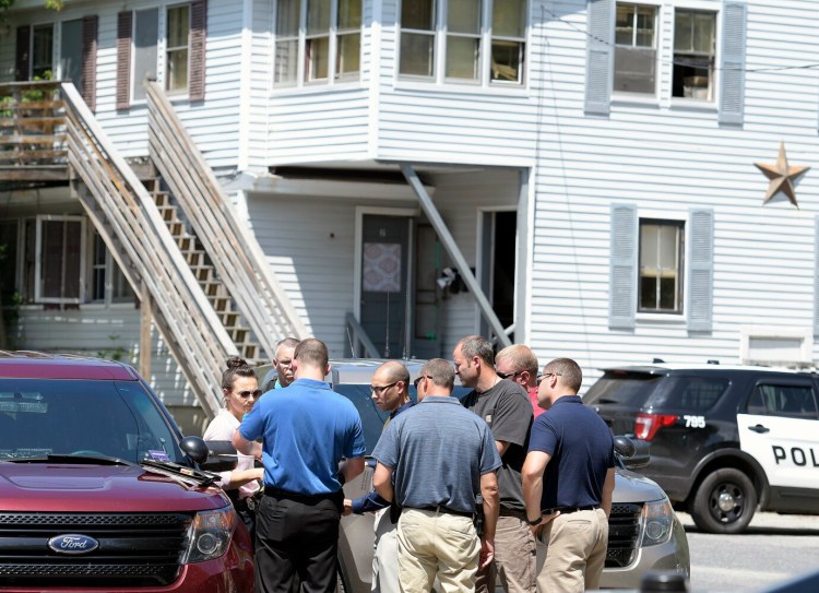 Police congregate Tuesday outside 37 Water St. in Augusta while investigating the death of a woman in the apartment building.