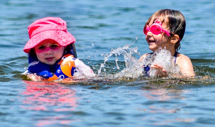 Oriana Murray, left, and Elizabeth Tripp splash on Friday in Maranacook Lake at the Winthrop town beach.