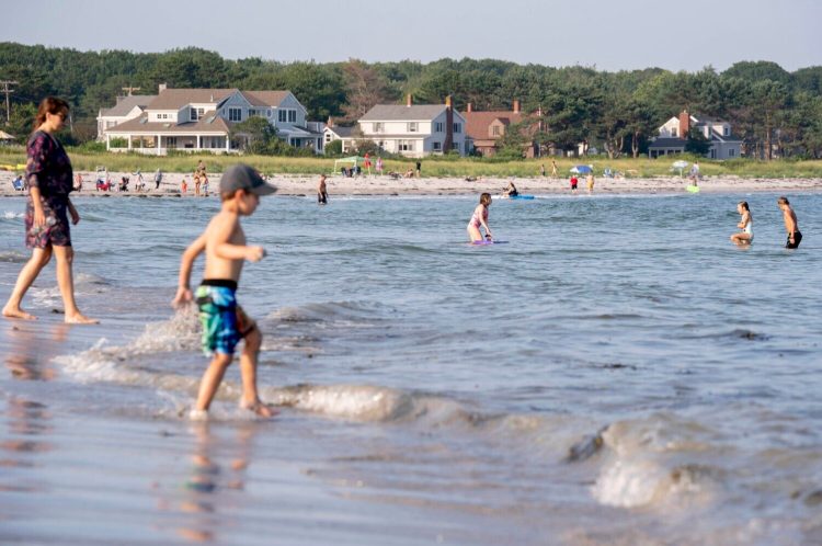 Swimmers enjoy the waves at Goose Rocks Beach in Kennebunkport this summer. The Maine Supreme Judicial Court upheld a lower court ruling that held there was no evidence the strip of sand was conveyed into private ownership in the deeds of the oceanfront property owners.