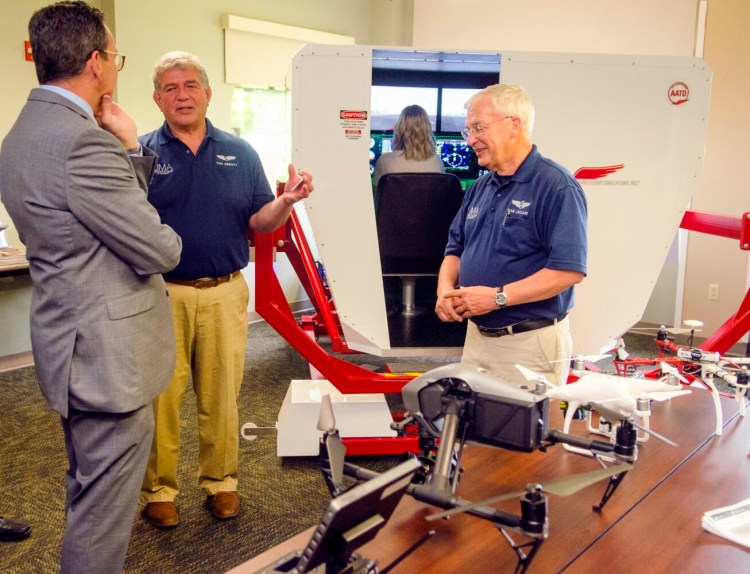 New University of Maine System Chancellor Dannel Malloy, left, chats with instructors Tom Abbott and Daniel Leclair about the flight simulator and drones used in the aviation program during a tour Tuesday at the University of Maine at Augusta.