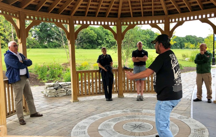 A man who would only identify himself as Greg, front center, speaks with Waterville police Chief Joseph Massey, left, and other city officials during a gathering Tuesday morning in the gazebo at RiverWalk at Head of Falls in Waterville.