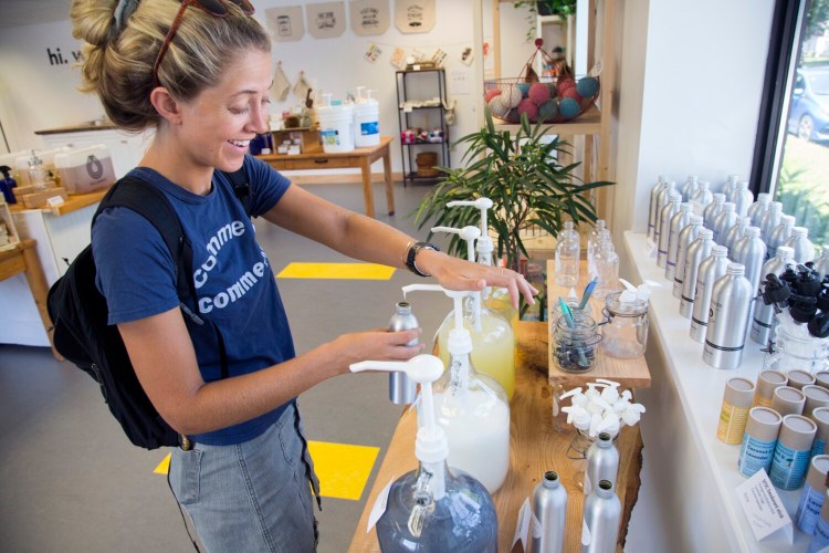 Lexi Doudera of South Portland fills a reusable container with conditioner at GoGo Refill on Friday. 