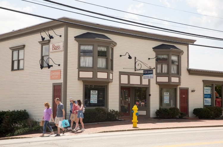 Shoppers walk past a retail space for lease on Main Street in Freeport. Both Kittery and Freeport have seen sales declines in the past five years, prompting some new initiatives to deal with that impact.