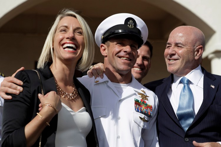Navy Special Operations Chief Edward Gallagher, center, walks with his wife, Andrea Gallagher, and advisor, Bernard Kerik as they leave the military court on Naval Base San Diego on Tuesday. A military jury acquitted the decorated Navy SEAL of murder in the killing of a wounded Islamic State captive under his care in Iraq in 2017.