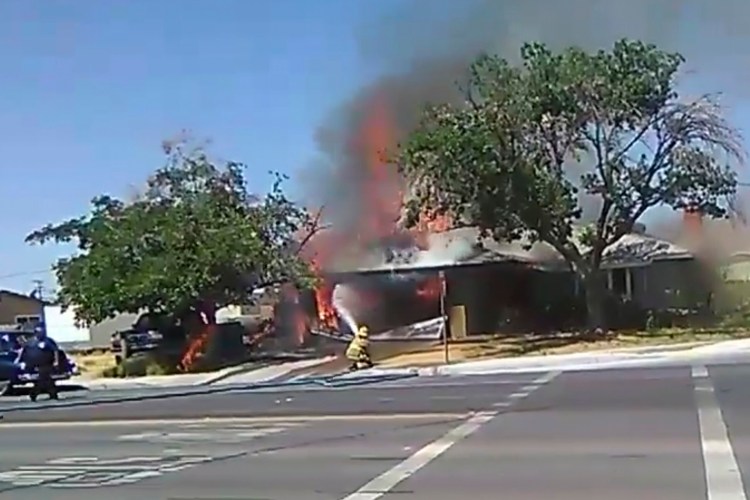 In this image taken from video provided by Ben Hood, a firefighter works to extinguish a fire Thursday after an earthquake in Ridgecrest, Calif.