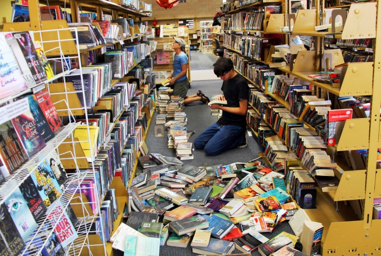 Volunteers assist with cleanup Friday at the Ridgecrest, Calif., branch of the Kern County Library, following a 6.4 magnitude earthquake that shook the region about 150 miles northeast of Los Angeles Thursday. The region was hit by an even stronger earthquake Friday evening.
