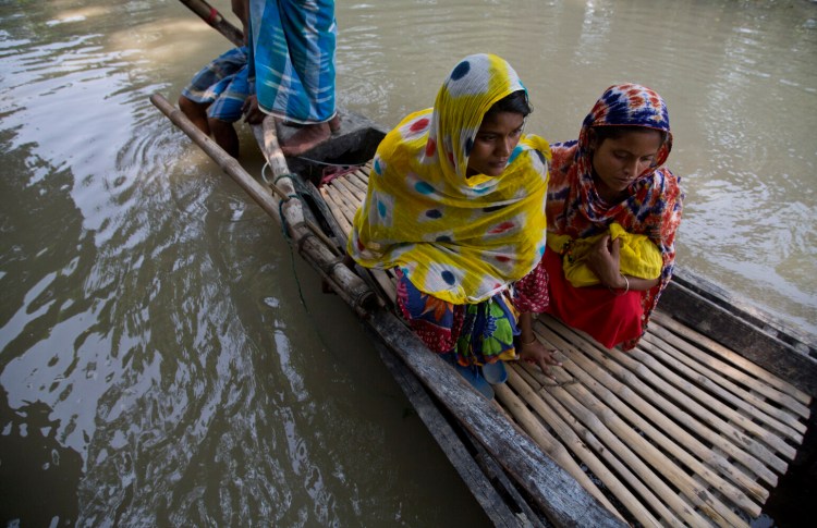 Imrana Khatoon, left, rides a boat to get to a hospital, as a woman sits beside her holding Khatoon's newborn baby, in flood-affected Gagalmari, India, on Friday. Khatoon, 20, delivered her first baby on a boat in floodwaters early Friday while on her way to a hospital, locals said. The woman and the newborn were brought back to their home without getting to hospital. They were however moved to a hospital on a boat in a nearby town because of unhygienic conditions due to floodwaters.