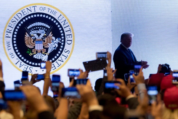 In this July 23, 2019 photo, President Donald Trump takes the stage at Turning Point USA Teen Student Action Summit in Washington. The White House says it had no warning that an altered presidential seal featuring a two-headed eagle clutching golf clubs would be shown at a speech by President Donald Trump this week. 