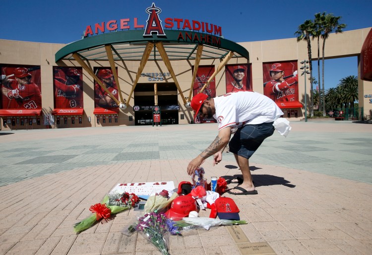 Los Angeles Angels fan Steven Beltran adds to a makeshift memorial at Angels Stadium in Anaheim, Calif., for pitcher Tyler Skaggs, who died Monday at the age of 27, in Texas, stunning Major League Baseball and leading to the postponement of the team's game against the Texas Rangers Monday.