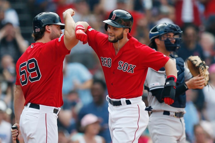 Andrew Benintendi celebrates his solo home run with Sam Travis during the Red Sox game against the New York Yankees on Saturday in Boston.