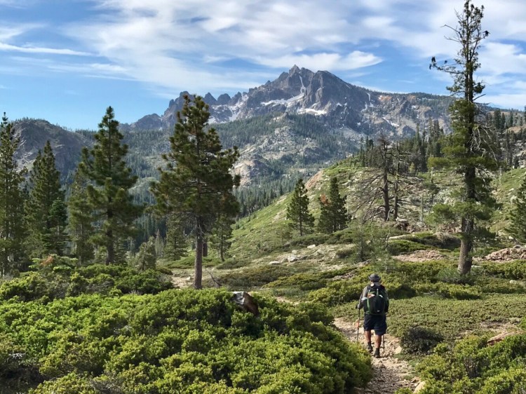 A hiker approaches the dramatic Sierra Buttes (8,857 feet in elevation) on the Pacific Crest Trail in the northern reaches of the Sierra Nevada. 
