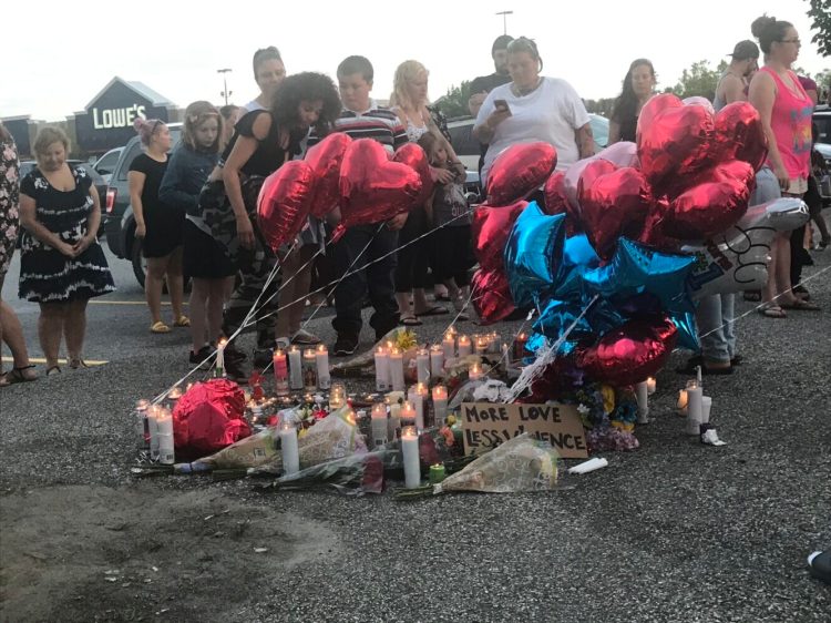 Friends and family members of Jean Fournier, 41, of Turner light candles and set them in a circle Sunday evening during a vigil at the Walmart parking lot in Auburn. Fournier was fatally shot Saturday evening in the parking lot on Mount Auburn Avenue.