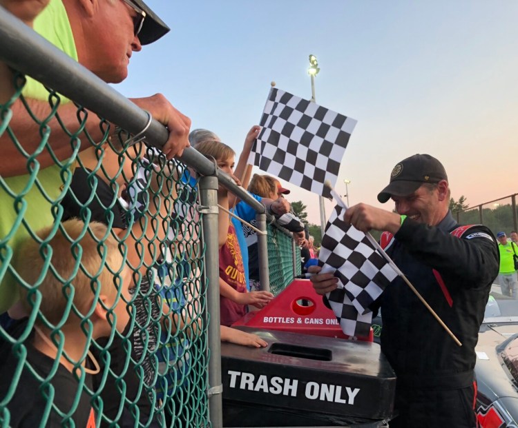 Kevin Douglass, far right, signs autographs in victory lane after winning a July 2019 Pro Stock feature at Wiscasset Speedway.