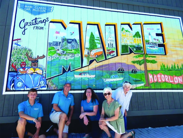 The team that worked on the massive 'Greetings from Maine' billboard-sized postcard gather Monday by the artwork. From left are Spencer Thiboutot, Tim Stentiford, Karen Sigler, Marley Raum and Danie Connolly.