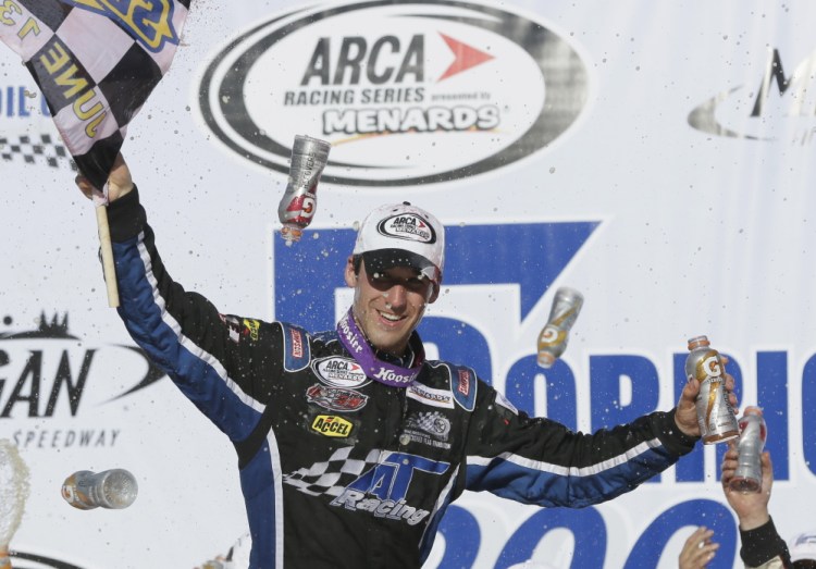 Fort Kent native Austin Theriault holds the checkered flag on June 13, 2014, after winning the ARCA Corrigan Oil 200 at Michigan International Speedway in Brooklyn, Mich.