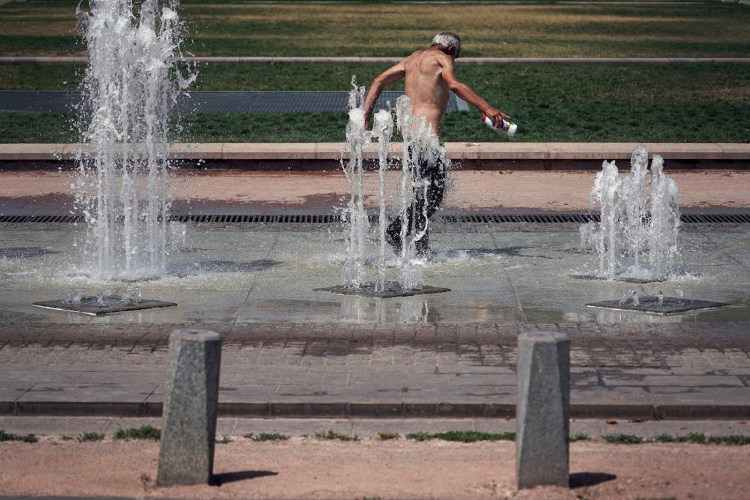 A man cools off in a fountain, in Lyon in central France on Wednesday.