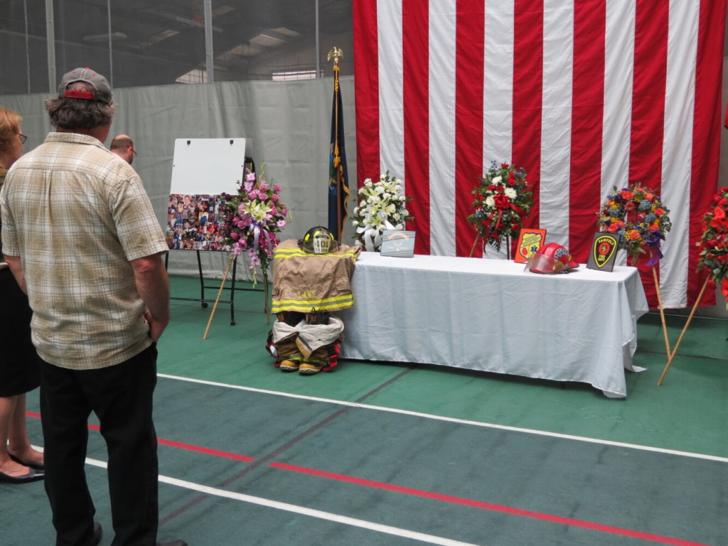 An attendee at Capt. Jim Lane's celebration of life service Sunday looks at the display table with photos of Lane as well as his Fairfield Fire Department uniform. 