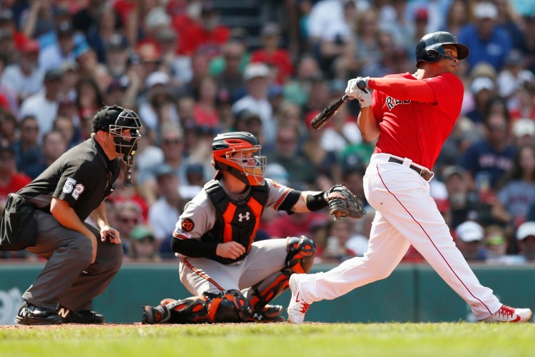 Rafael Devers, right, follows through on an RBI double in the sixth inning of Boston's 13-7 win over Baltimore on Sunday at Fenway Park. Devers had four hits, including two doubles and a home run, and four in four runs.