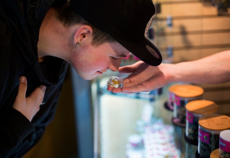 Ben Brooks, 19, of Windham takes a whiff of a some "dabs," which are concentrated doses of cannabis, while shopping for medical marijuana at Ganja Candy Factory in Portland in 2018.