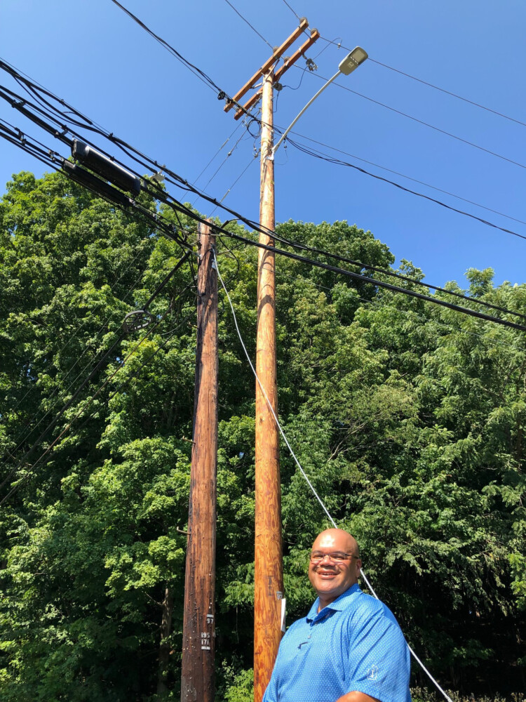 Lloyd Hendrix, who's overseeing Central Maine Power's plan to harden its electric grid against storm and tree damage, shows the contrast between an older, thinner utility pole and the taller, stronger version that replaced it along Route 101 in Eliot. The circuit here has among the worst records for power outages in CMP's system, and is targeted for an upgrade this fall as part of a 10-year, network-wide proposal. 