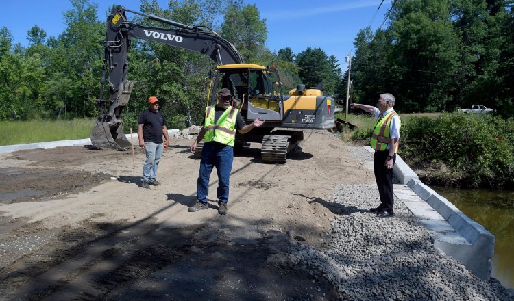 Monmouth Town Manager Curt Lunt, right, speaks Monday with Public Works Director Bruce Balfour, center, and excavator operator Chet Blair on the overpass above the new culvert on the Sanborn Road in Monmouth. The road near the intersection of Route 135 was closed when the culvert backed up in April 2018 and partially collapsed the road. Work on the overpass should be complete by the first week of September, according to contractor P.J. Poirier, who was awarded the $180,000 contract.