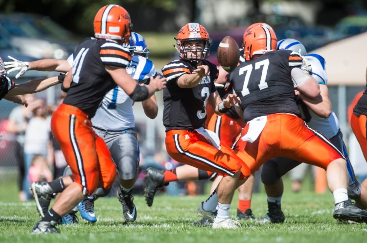 Winslow quarterback Colby Pomeroy (3) pitches the ball to Ben Dorval during a game against Lawrence last season in Winslow. The Black Raiders return 18 letter winners and should be a force in Class C North this fall. 