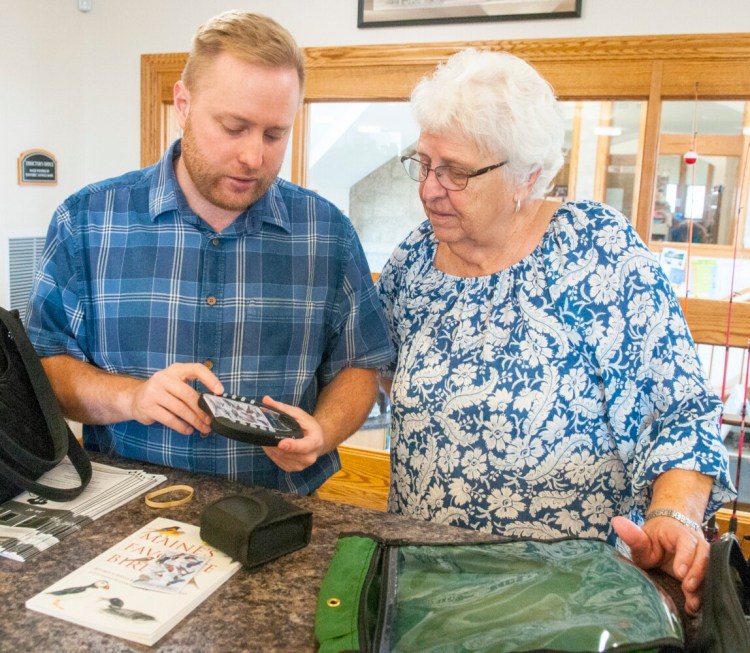 Library director Richard Fortin, left, shows Mary Jane Auns how to use the bird call identifying device that is part of the bird watching kit on Friday at Charles M. Bailey Public Library in Winthrop.