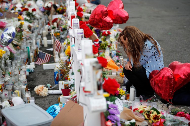 Gloria Garces kneels at a makeshift memorial last month near the scene of a mass shooting in El Paso, Texas. The National Rifle Association called a Texas Republican's gun control proposal a "political gambit."