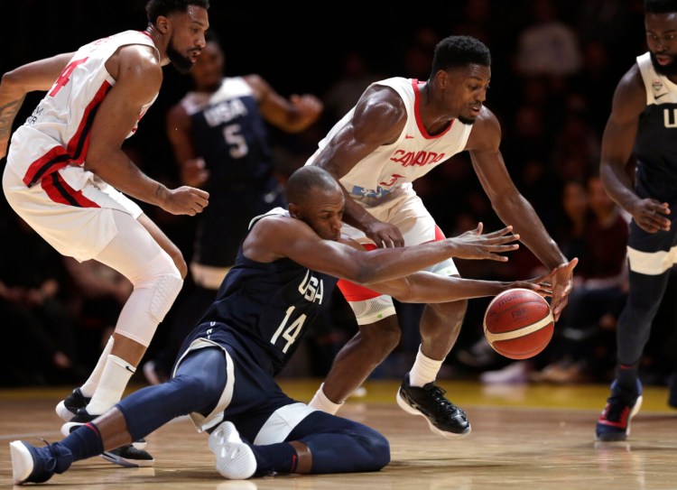 Canada's Melvin Ejim, second right, and Khris Middleton of the United States, second left, compete for the ball during the United States' 84-68 win in an exhibition game Monday in Sydney, Australia.