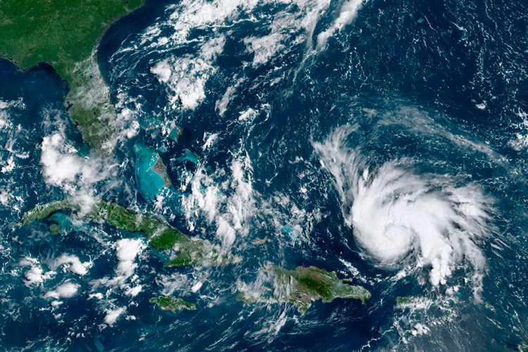 This GOES-16 satellite image taken Thursday and provided by the National Oceanic and Atmospheric Administration shows Hurricane Dorian, right, moving over open waters of the Atlantic Ocean.