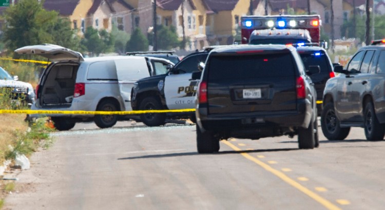 Odessa and Midland police and sheriff's deputies surround a white van in Odessa, Texas, on Saturday. 