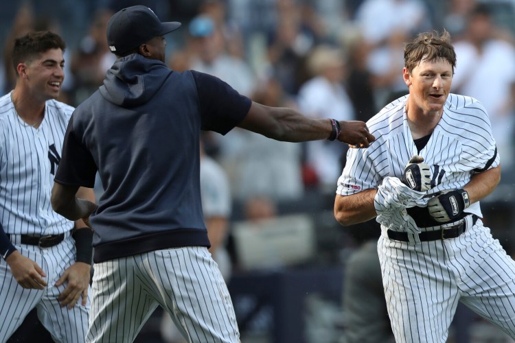 New York Yankees' DJ LeMahieu, right, celebrates with his teammates after hitting the game-winning walk off home run in the 11th inning of a baseball game against the Oakland Athletics, Saturday, Aug. 31, 2019, in New York. (AP Photo/Mary Altaffer)