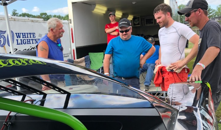 Ben Ashline, second from right, and car owner Ajay Picard, far right, look over their No. 99 during practice for a Pro All Stars Series race at Oxford Plains Speedway in July.