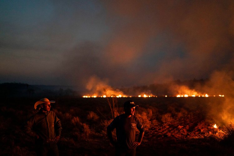 Neri dos Santos Silva, center, watches an encroaching fire threat after digging trenches to keep the flames from spreading to the farm he works on, in the state of Mato Grosso, Brazil, on Friday. Associated Press/Leo Correa