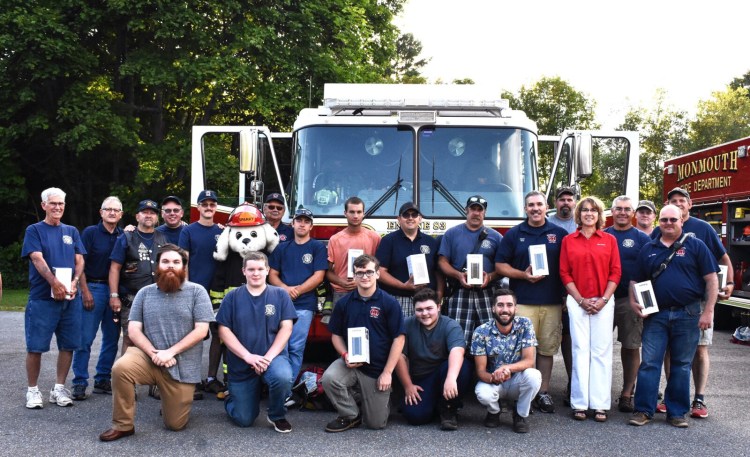 Lisa Laliberte and colleagues from State Farm Insurance attended National Night Out Aug. 6 at the Monmouth Police Department to present 46 devices to Monmouth Firefighters. Front from left are Gabriel Henson of State Farm, junior firefighters Payton Beasley, Connor Harding and Matt Pagnani, and Benjamin Daigle of State Farm.  Back from left are Jimmy Price, Dan Niles, Ed Garnier, Hugh Lemaster, Lt. Ron Cook, Sparky, Assistant Chief Ken Palleschi, Keegan Foster, Nate St. Laurant, Capt. Jason Mills, Luke Boucher, Chief Dan Roy, Scott Beasley, Lisa Laliberte of State Farm, Jerry Robinson, Josh Reny, Lt. Lance Reny and Lt. Greg Koller.