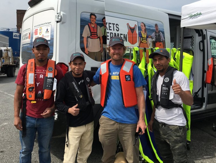 Lobstermen (l. to r.) Salomon Tamup, Humberto Cach, Chris Chase and Josue Ruiz try lifejackets in New Bedford, Massachusetts. 