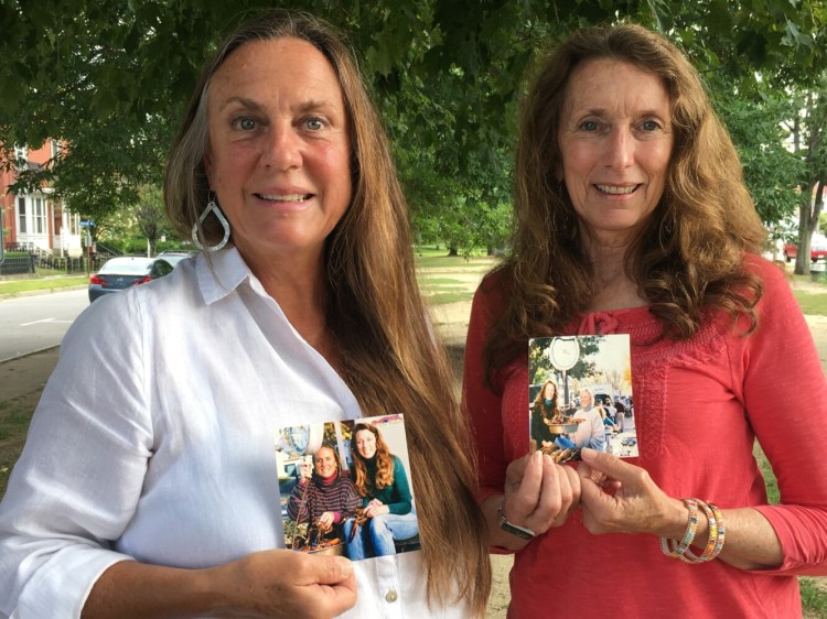 Nancy Curtis-Strange, left, and Kathleen Clemons, better known as the Lobster Ladies, hold 15-year-old photos of themselves selling lobsters. After 42 years of selling lobsters together, the sisters-in-law will sell lobsters for the last time Saturday in the parking lot of Fat Boy in Brunswick.