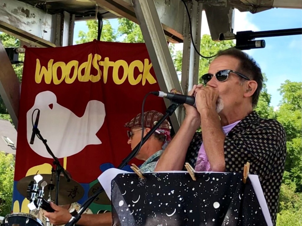Jay Conway, of the band Canned Heat, plays the harmonica Sunday during Hallowell's Woodstock and Art Festival.
